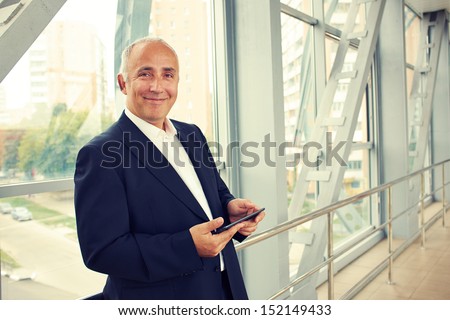 Stok fotoğraf: Portrait Of Confident Handsome Serious Businessman Holding Laptop In His Hands On Black Background W