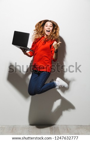 Foto stock: Full Length Photo Of Charming Woman 20s Wearing Red Sweatshirt J