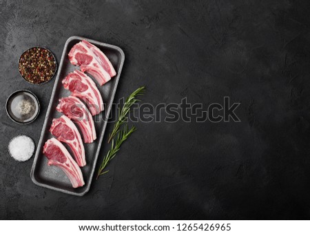 Foto stock: Fresh Raw Butchers Lamb Beef Cutlets In Plastic Tray With Vintage Meat Hammer On Black Backgroundsa