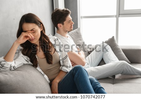 Foto stock: Photo Of Disappointed Couple Sitting Together On Sofa At Home Wi