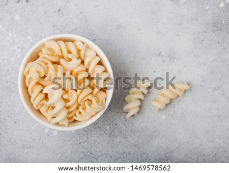 Foto d'archivio: Salt And Vinegar Potato Twirls In White Bowl Classic Snack On Black Kitchen Table Background