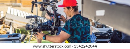 ストックフォト: Steadicam Operator And His Assistant Prepare Camera And 3 Axis Stabilizer Gimbal For A Commercial Sh