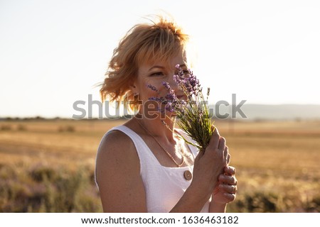 Stockfoto: Happy Middle Age Blond Woman In White Posing On Lavender Field