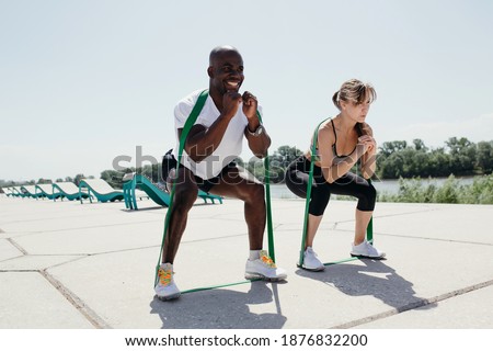 Foto stock: Young Athletic Man And Woman Stretching Outdoors On A Hot Summer