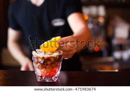 Foto stock: Barman Is Decorating Cocktail With Slise Orange At Night Club C