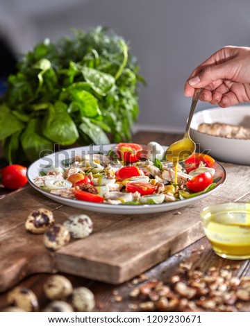 Stock photo: Female Hand Puts Walnuts To The Plate Of Freshly Cooked Salad From Natural Ingredients On A Wooden T