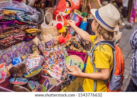 Stockfoto: Boy At A Market In Ubud Bali Typical Souvenir Shop Selling Souvenirs And Handicrafts Of Bali At Th