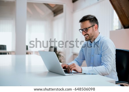 Stok fotoğraf: A Young Man Sits In The Office At A Computer Desk And In Front Of Him Stands A Globe