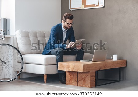 [[stock_photo]]: Handsome Young Man Working With Touchpad While Sitting On The Co