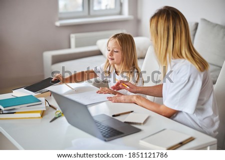 Stock fotó: Side View Of Happy Mother With Her Young Daughter Reading Storybook In Bedroom At Home