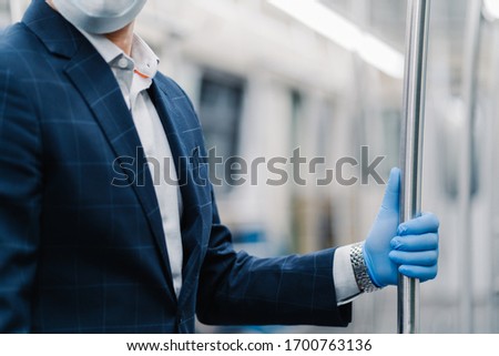 Foto stock: Mans Hand In Blue Disposable Glove Touching Handrail In Public Transport Pandemic Precaution Prote