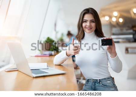 Stockfoto: Young Businesswoman Showing Her Business Card - Sitting At Her O