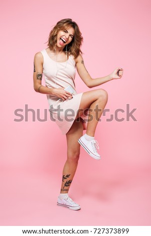 Stok fotoğraf: Attractive Woman With Headphones Posing While Standing Against A White Background