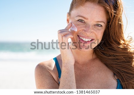 Сток-фото: Young Red Woman With Beautiful Smile Cream Is Applied To Skin