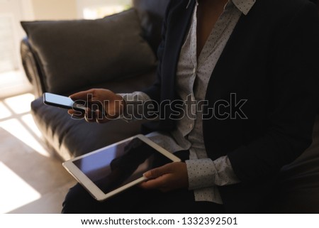 Foto d'archivio: Mid Section Of Female African American Real Estate Agent Using Mobile Phone While Holding Digital Ta