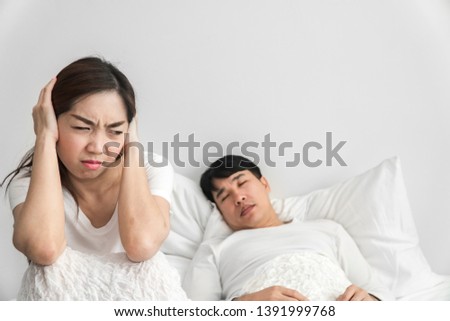 Foto stock: Young Woman Lying On A Bed Covered Her Ears Because Of The Noise In The Window After The Bed You Ca