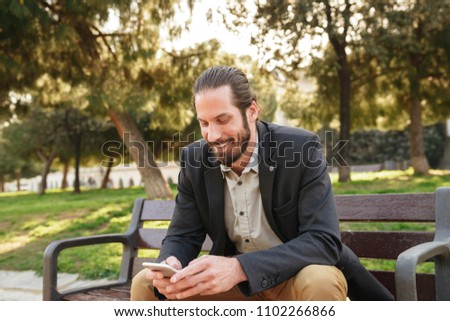 Zdjęcia stock: Picture Of Handsome Bearded Man 30s In Businesslike Suit Holding