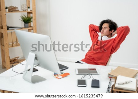 Stock fotó: Serene Young Male Freelancer Daydreaming By Desk With His Hands Behind Head