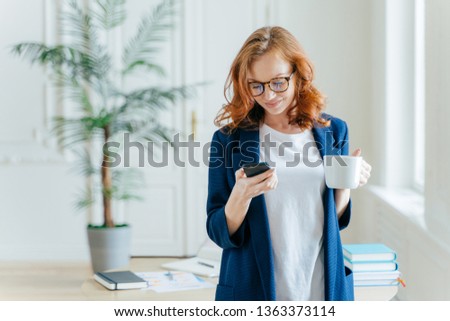 Foto d'archivio: Successful Female Ceo Reads Notification On Modern Cell Phone Has Coffee Break Dressed In Formal C