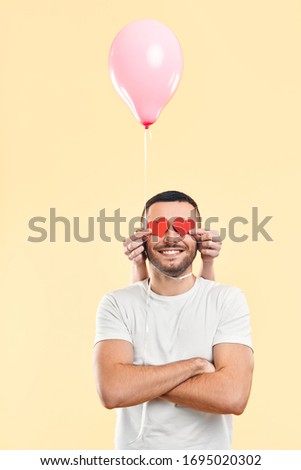 Foto stock: Weird Funny Man With Small Paper Hearts By Their Eyes And Pink Air Balloon On His Neck