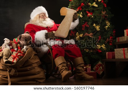 Foto stock: Portrait Of Happy Santa Claus Reading Christmas Letter Or Wish L