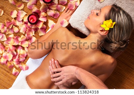 Stockfoto: Woman On Spa Or Massage With Flowers And Cosmetics On Foreground
