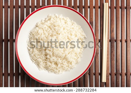 Foto d'archivio: White Rice Basmati In Wooden Bowl On Brown Bamboo Board Closeup