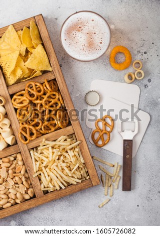 Zdjęcia stock: Glass Of Craft Lager Beer And Opener With Box Of Snacks On Wooden Background Pretzelsalty Potato S