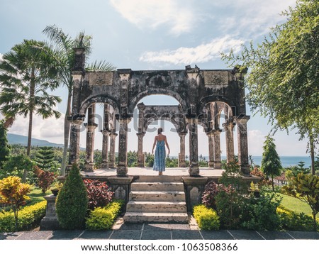 ストックフォト: Young Woman In Dress In Water Palace Soekasada Taman Ujung Ruins On Bali Island In Indonesia Amazin
