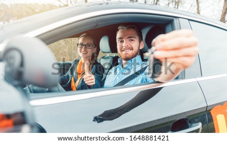 Foto stock: Student Of Driving School Having Passed His Final Test Showing The Car Keys