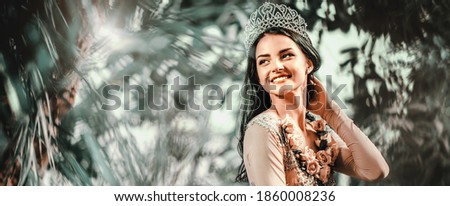 Foto stock: Gorgeous Lady In Evening Dress And With Tiara On A Head Posing In A Forest