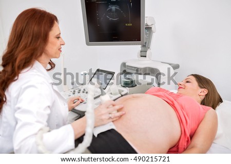 Foto d'archivio: Onna · incinta · che · ottiene · ultrasuoni · dal · medico · con · l'orologio · del · marito