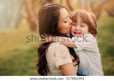 Stock fotó: Young And Happy Mother Cares For Her Young Son And Walks Along The Shore Of The Lake In The Summer