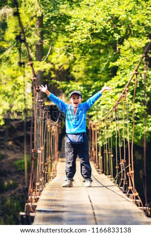 ストックフォト: Joyful Boy On A Suspension Bridge Awesome Adventure In A Wilderness With Family