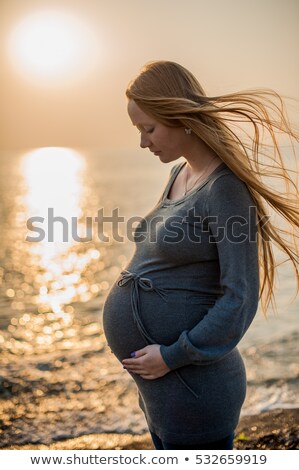 Сток-фото: Pregnant Young Woman Standing On The Beach In A Gray Knitted Dress Pregnancy Concept