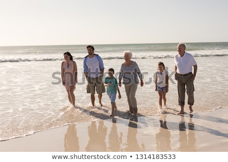 Foto stock: Front View Of Happy Multi Generation Family Walking And Having Fun On Beach In The Sunshine