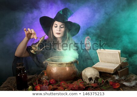 Foto d'archivio: Halloween Witch Cooking In A Copper Cauldron