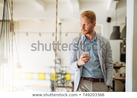 Сток-фото: Young Casual Man On His Phone Looks Away