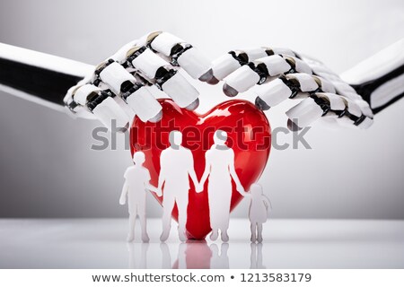 Foto stock: Robot Protecting Family Figures With Red Heart