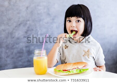 Foto d'archivio: Cuttle Black Hair Little Girl Having Breakfast And Eat Lettuce