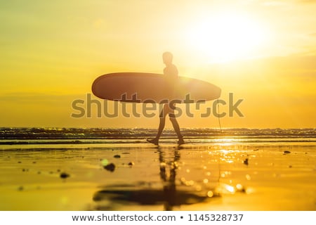 Сток-фото: Vacation Silhouette Of A Surfer Carrying His Surf Board Home At Sunset With Copy Space