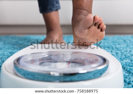 Foto stock: Human Foot Stepping On Weighing Scale
