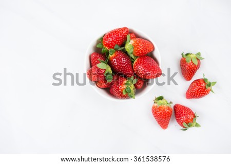 [[stock_photo]]: Bowl Of Fresh Strawberries On The White Table With Green Leaves