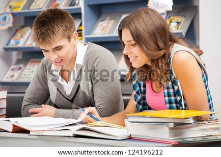 Foto d'archivio: Beautiful Happy Students Studying And Flirting In A Library