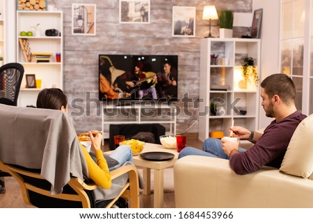 Foto stock: Os · mujeres · en · la · sala · de · estar · viendo · la · televisión · comiendo · chocolates · S