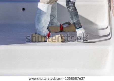 Foto stock: Worker Wearing Sponges On Shoes Smoothing Wet Pool Plaster With