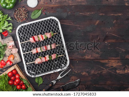 [[stock_photo]]: Raw Pork Kebab With Paprika On Disposable Coal Bbq Grill With Fresh Vegetables On Wooden Background