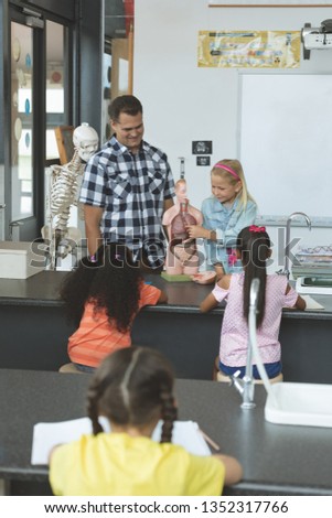 Zdjęcia stock: Front View Of A Caucasian Schoolgirl Explaining To Others School Kids The Human Body With His Teache