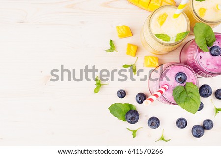 Stockfoto: Violet Blueberry Fruit Smoothie In Glass Jars With Straw Mint Leaves Berries Close Up White Wood