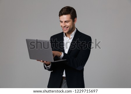 Foto stock: Image Of Cheerful Businessman 30s In Suit Rejoicing While Using